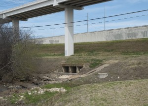 Emergence of Shoal Creek from beneath US 183, by Ted Lee Eubanks