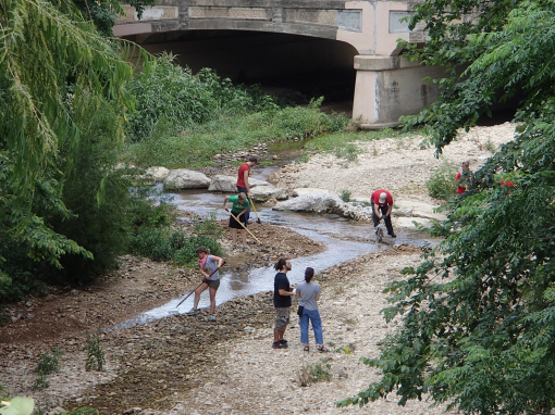 Volunteers clearing the low water crossing at the gap in the trail, south of 5th Street, to make it passable for cyclists.